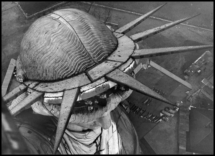 Visitors peek out from under the crown of the Statue of Liberty